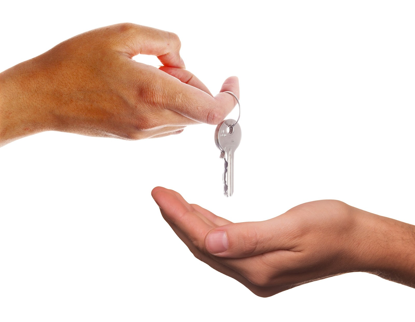 a hand passing over a set of house keys to someones palm