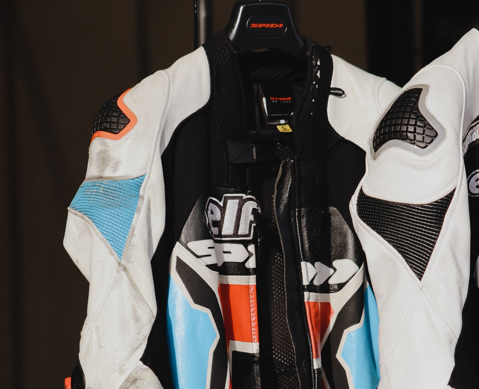 A protective motorbike suit hanging on a clothes hanger