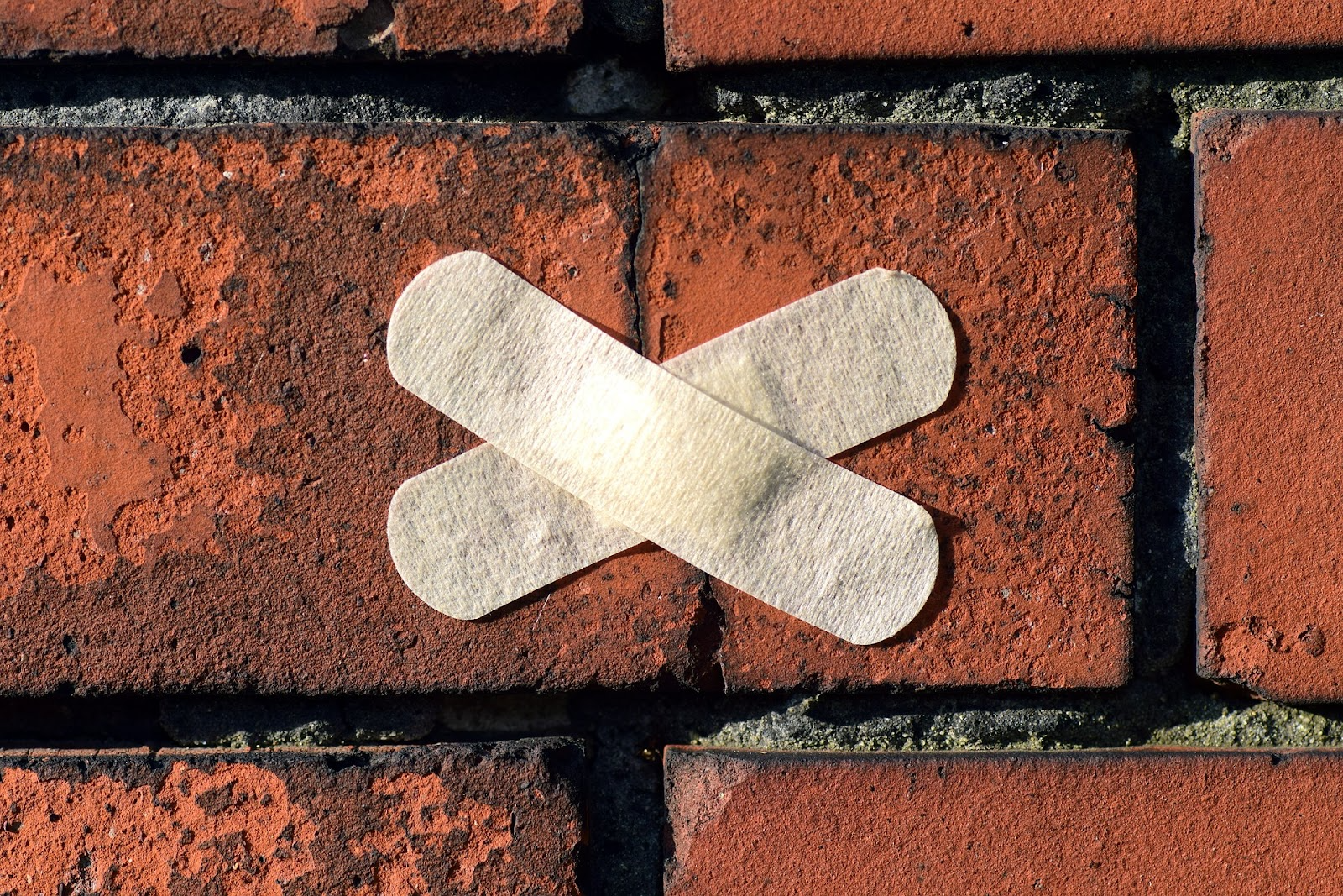 a plaster covering up cracks in a red brick wall