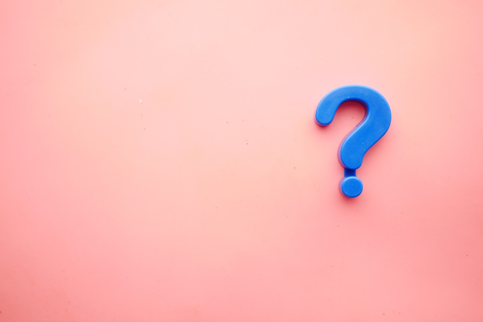 a blue question mark against a peach coloured background