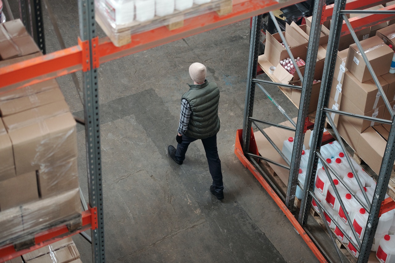 Man in beanie walking through a packed warehouse
