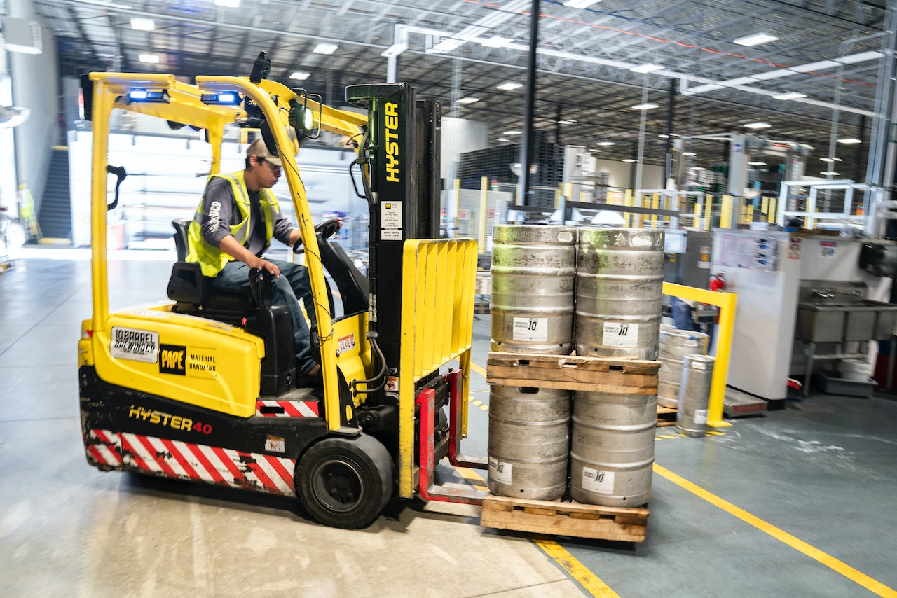 A forklift in a warehouse moving kegs