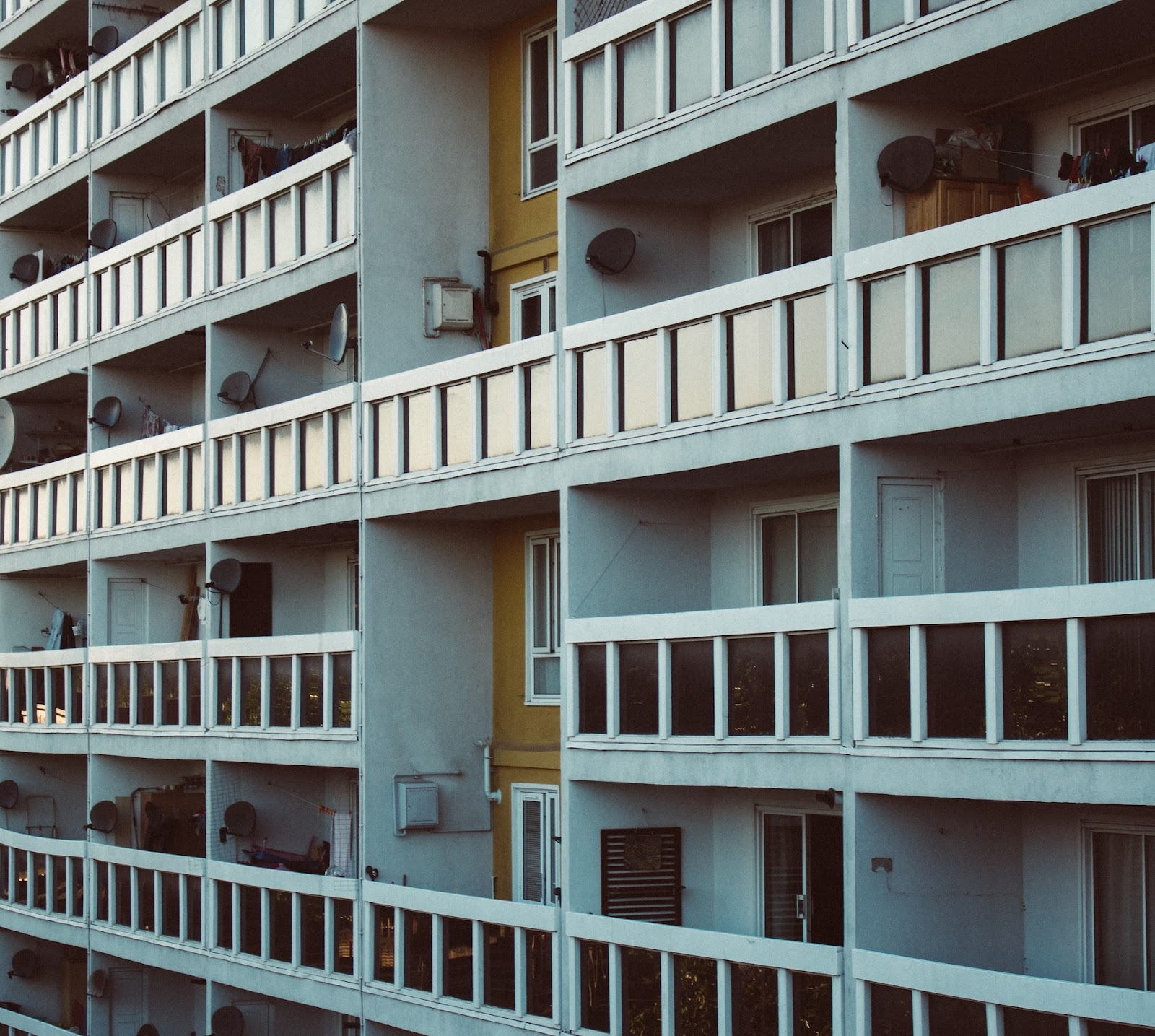 A block of pale blue flats with balconies