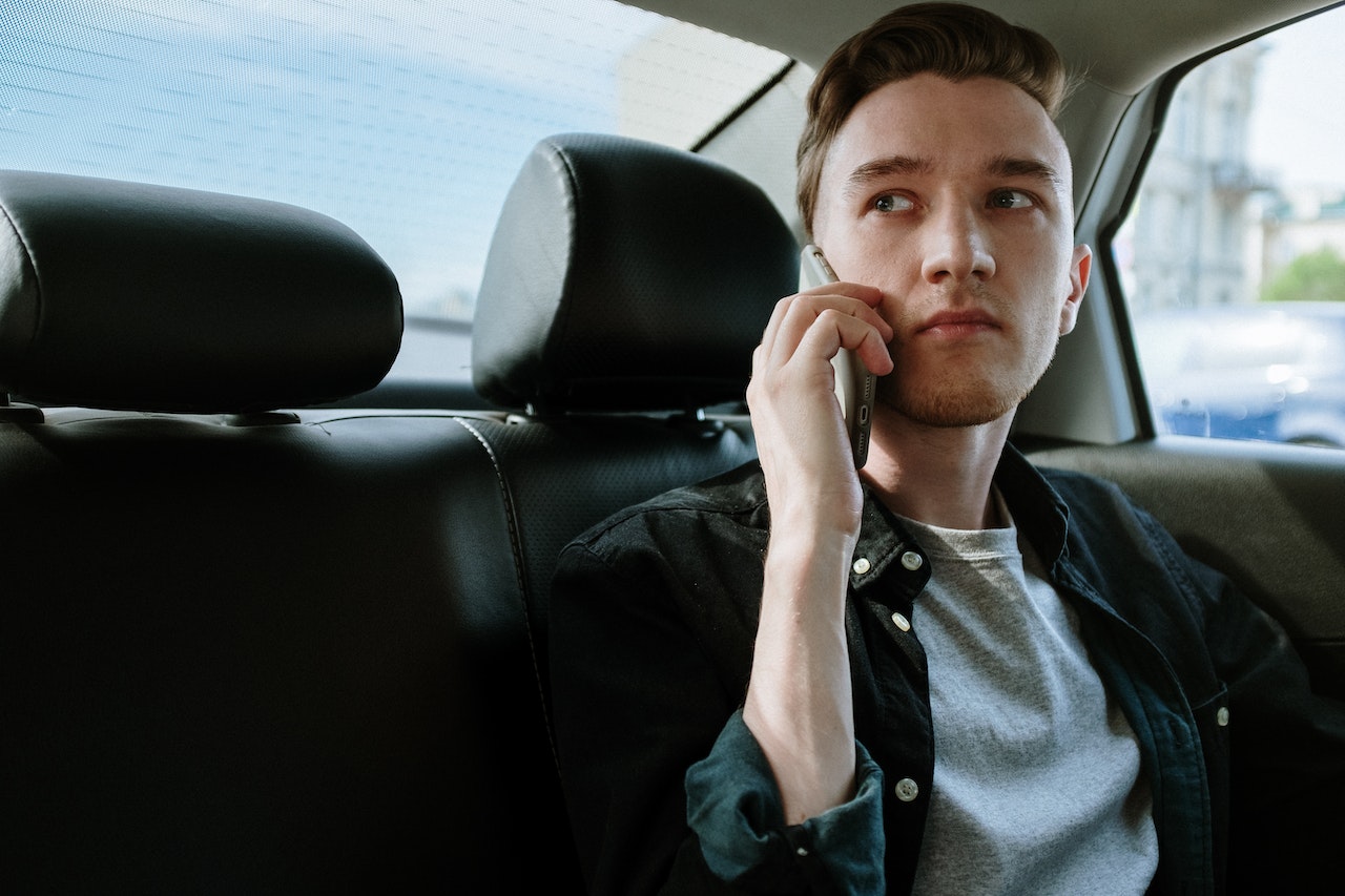 man sitting in the back of a car on the phone