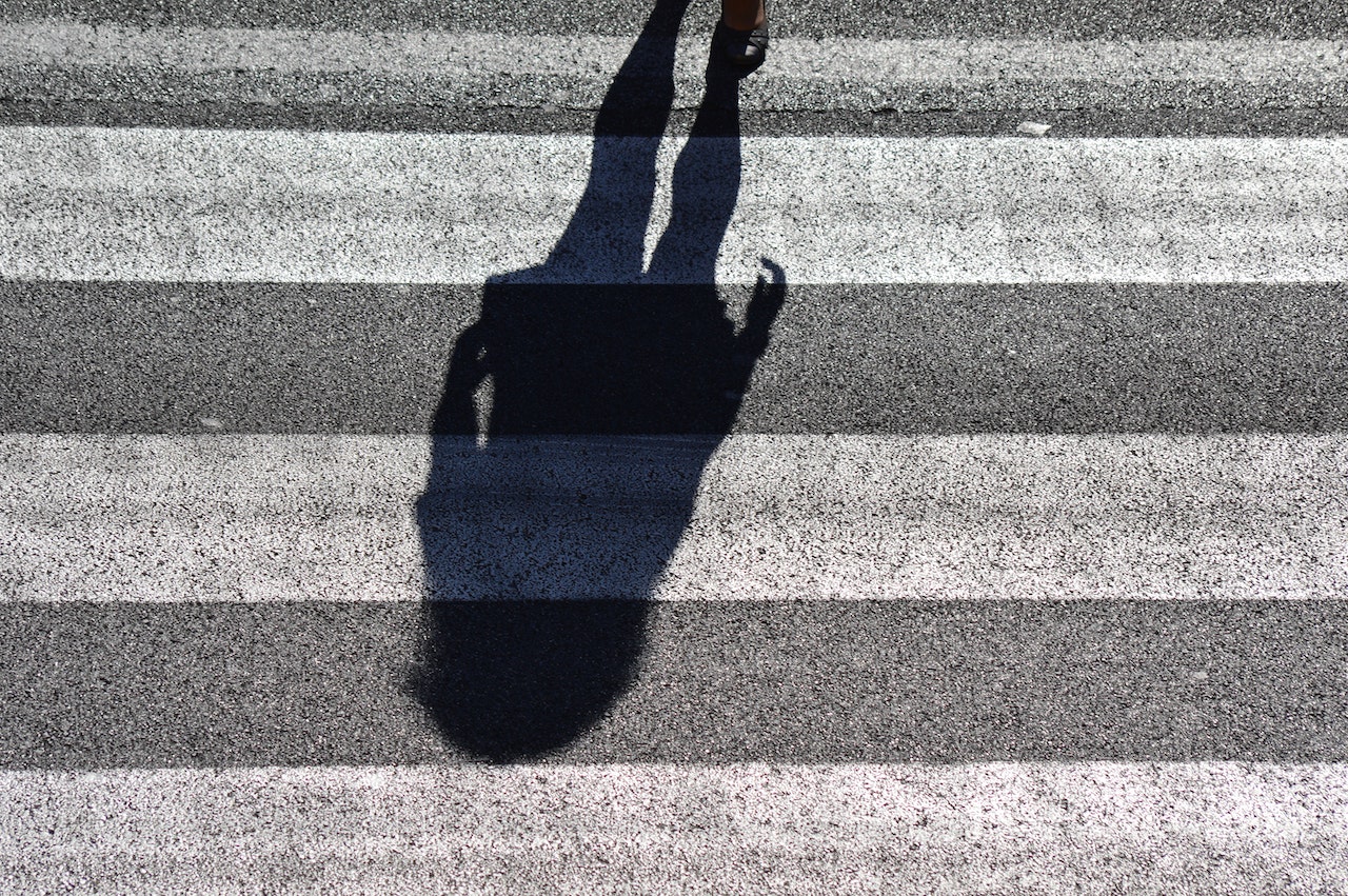 persons shadow at a pedestrian crossing