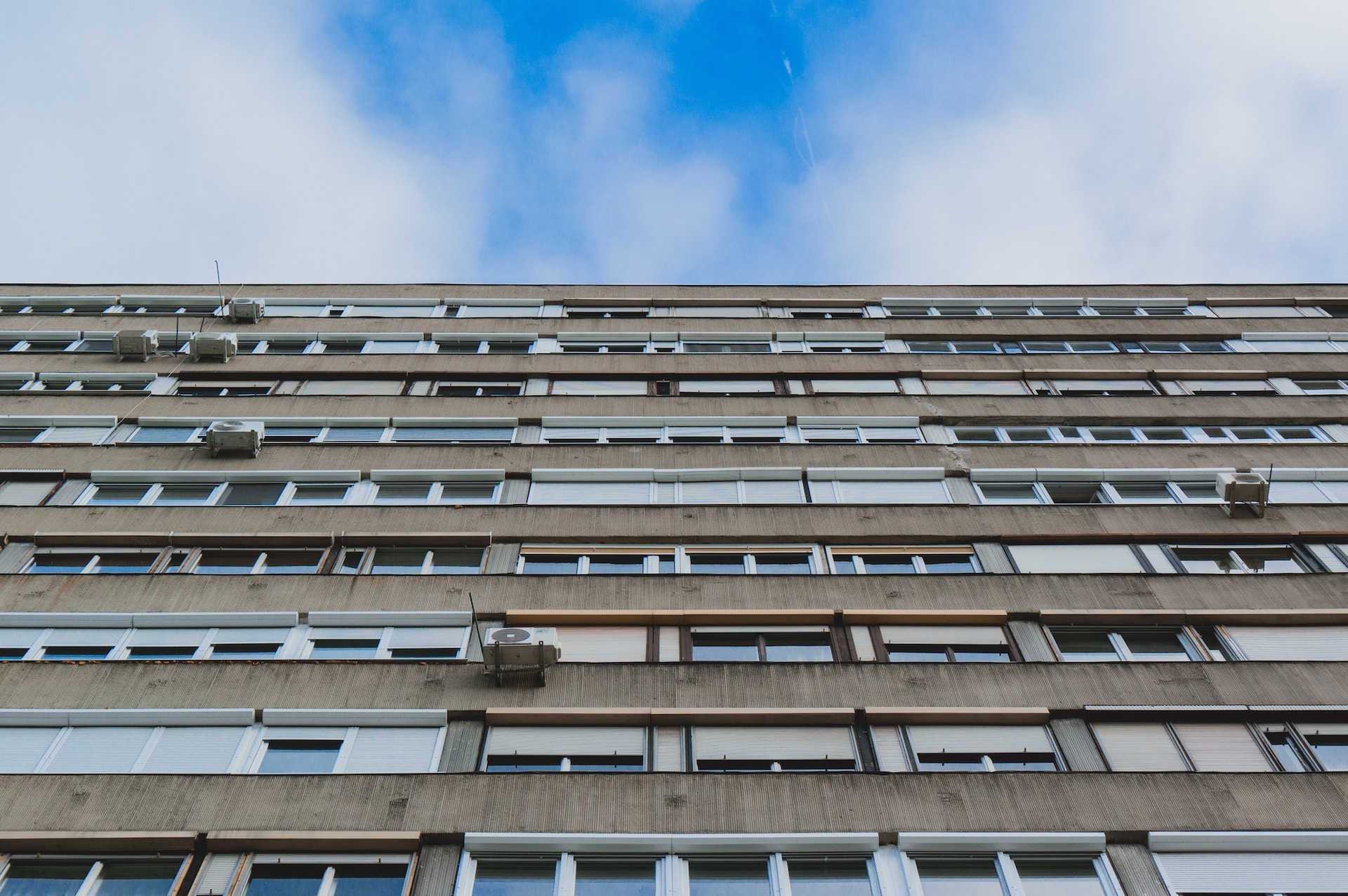 an upward shot of a grey block of flats