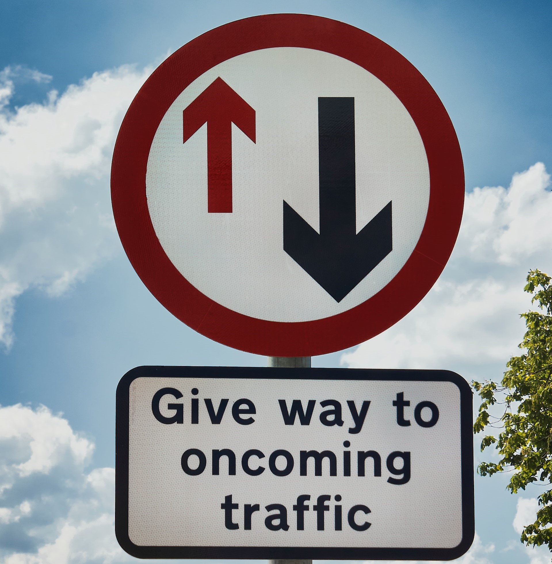 A road sign saying 'Give way to oncoming traffic'