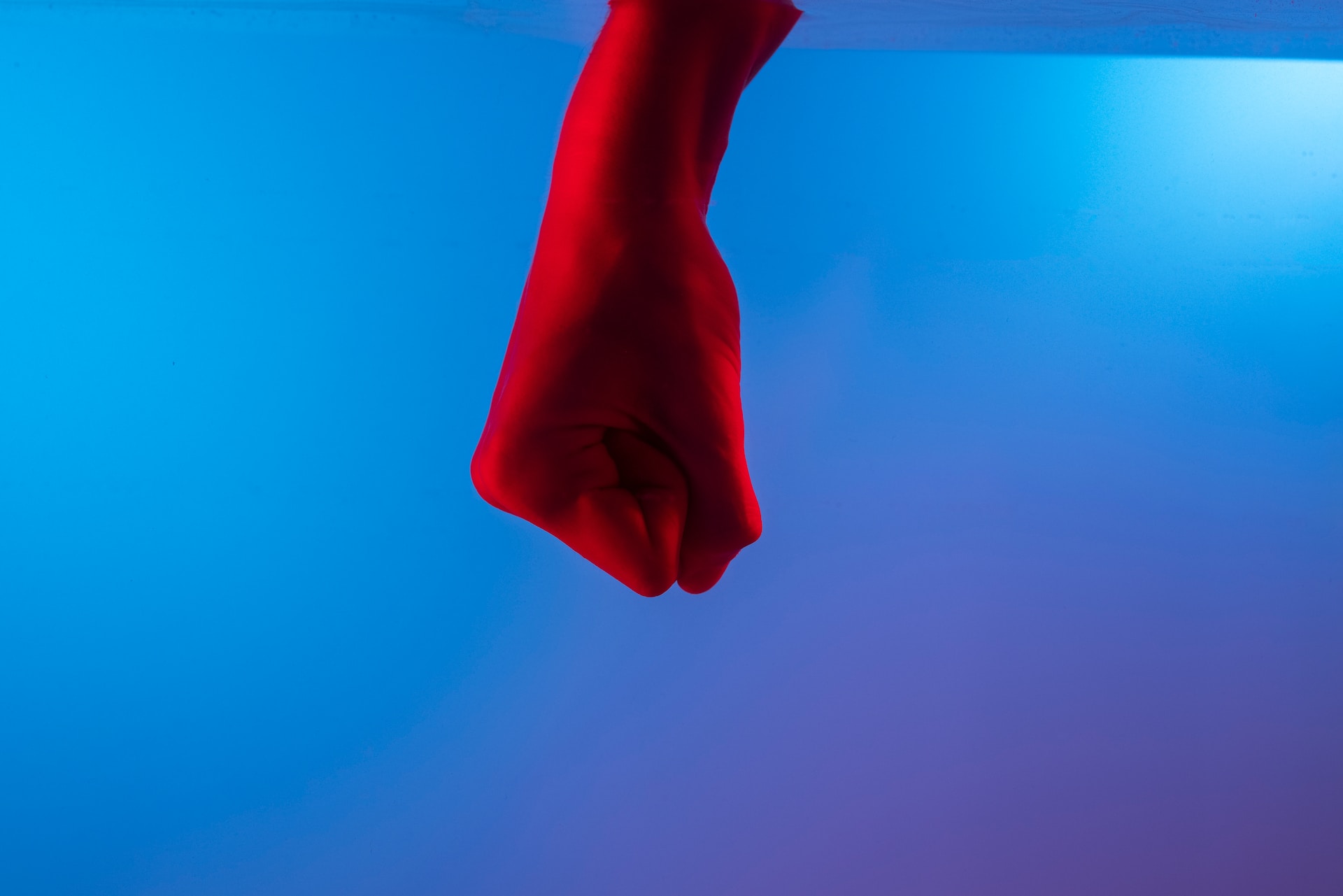 A closed fist against a blue background