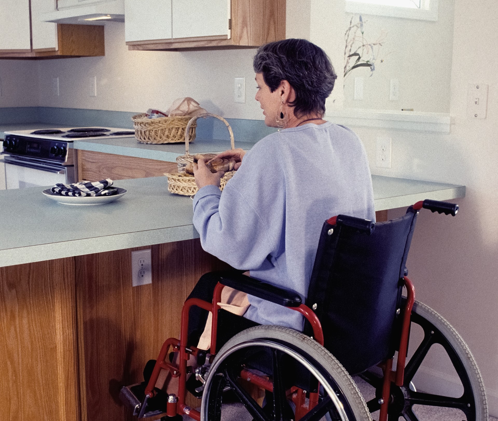 Someone in a wheelchair preparing food in their kitchen