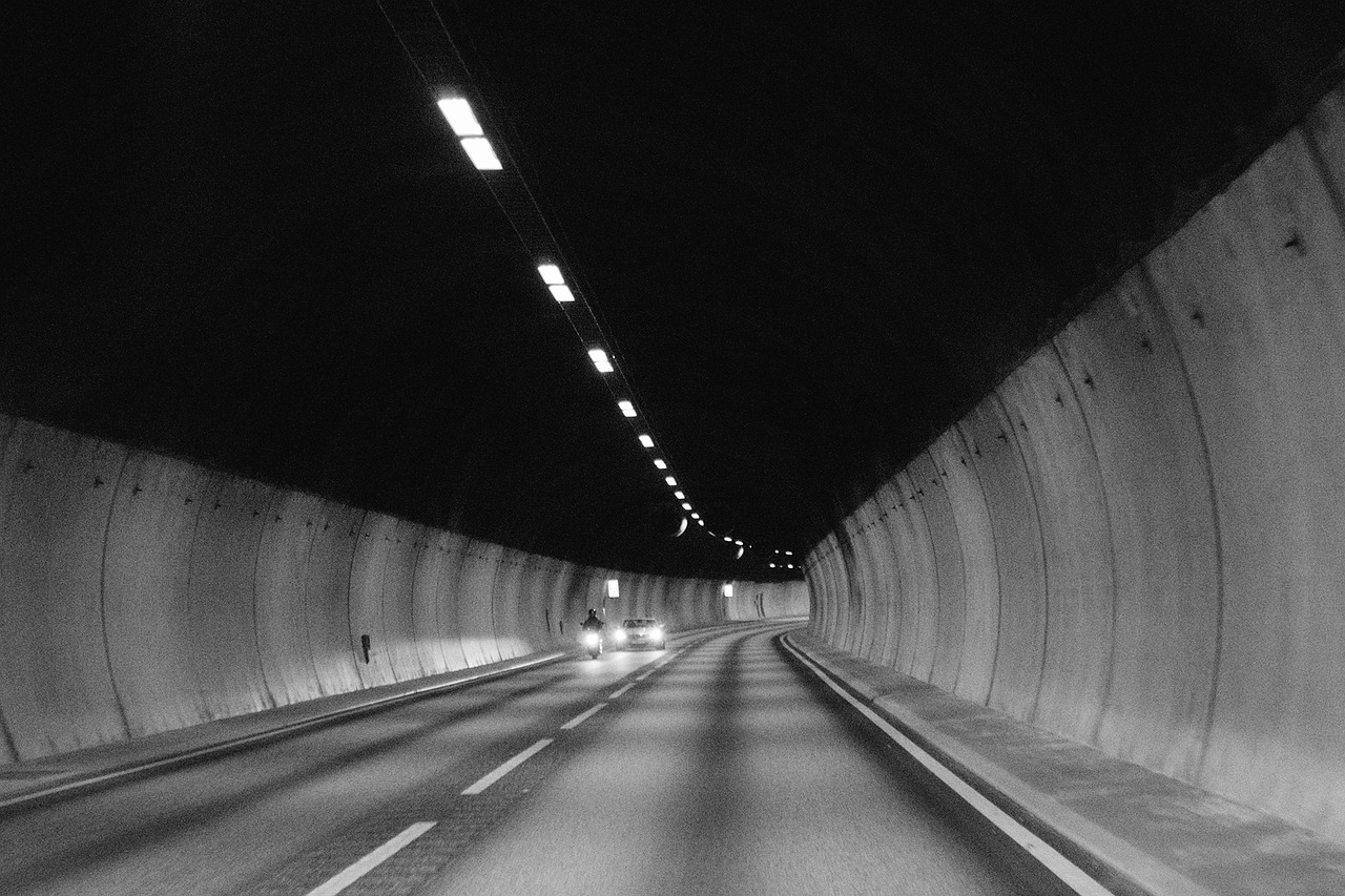 A car and a motorbike driving through a tunnel