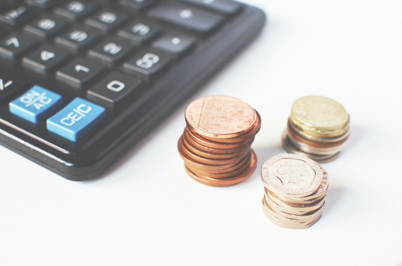 A calculator next to coins