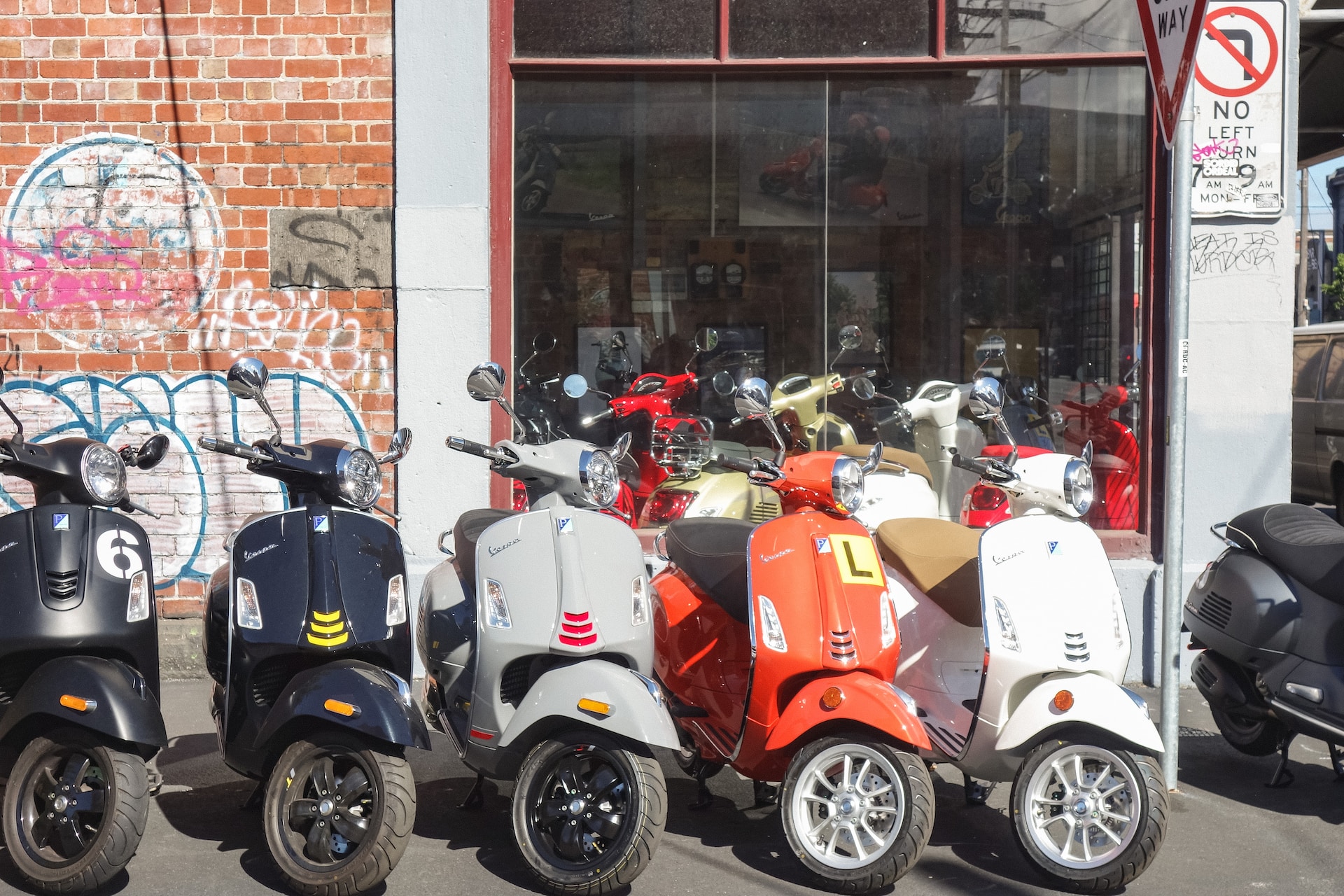 A row of mopeds parked on a corner