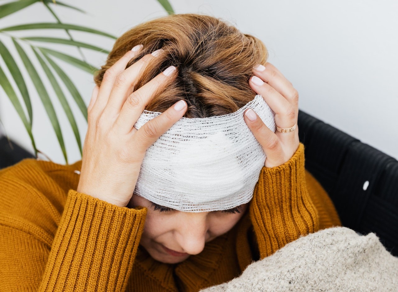A woman holding her bandaged head