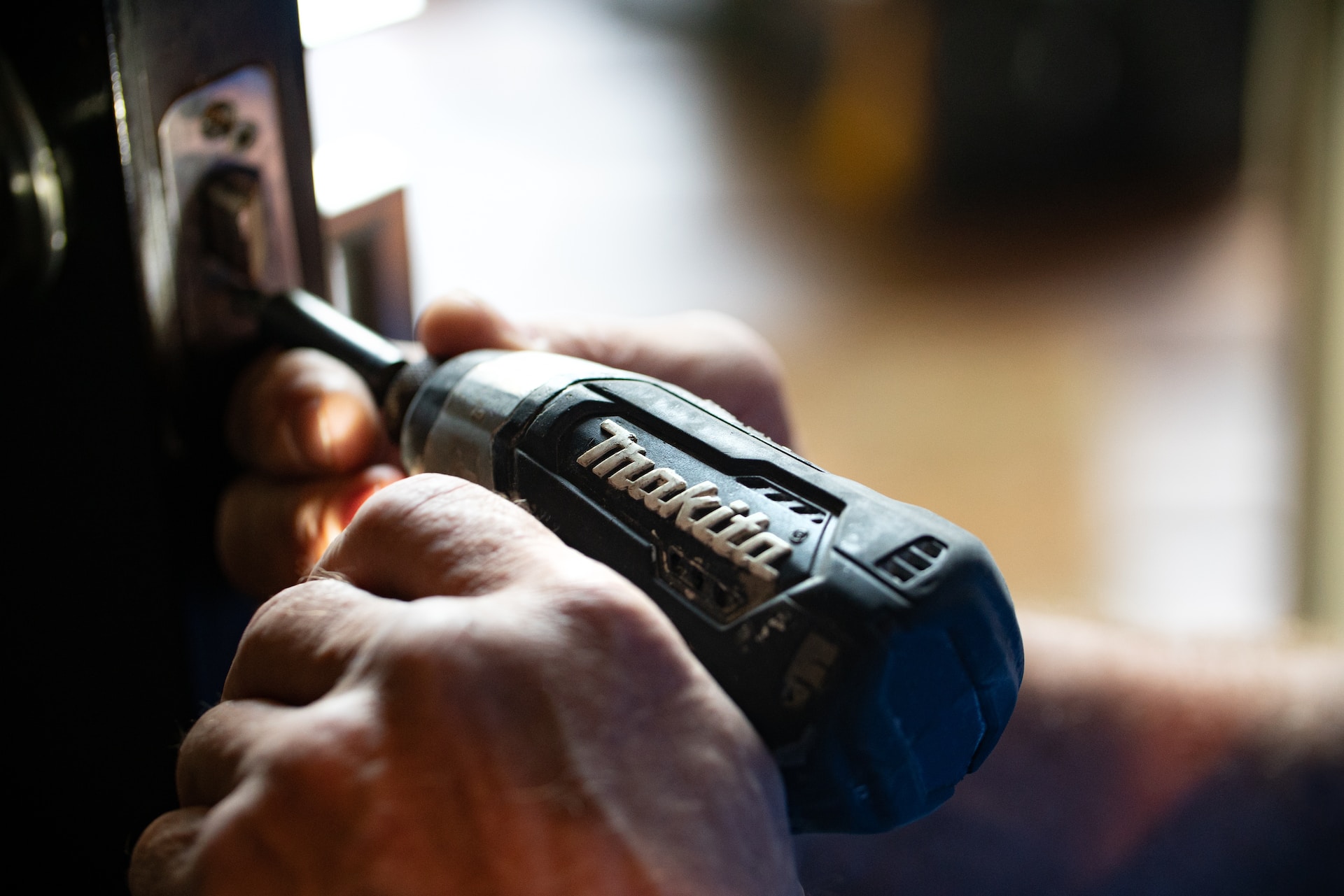 An electric drill fixing a door lock
