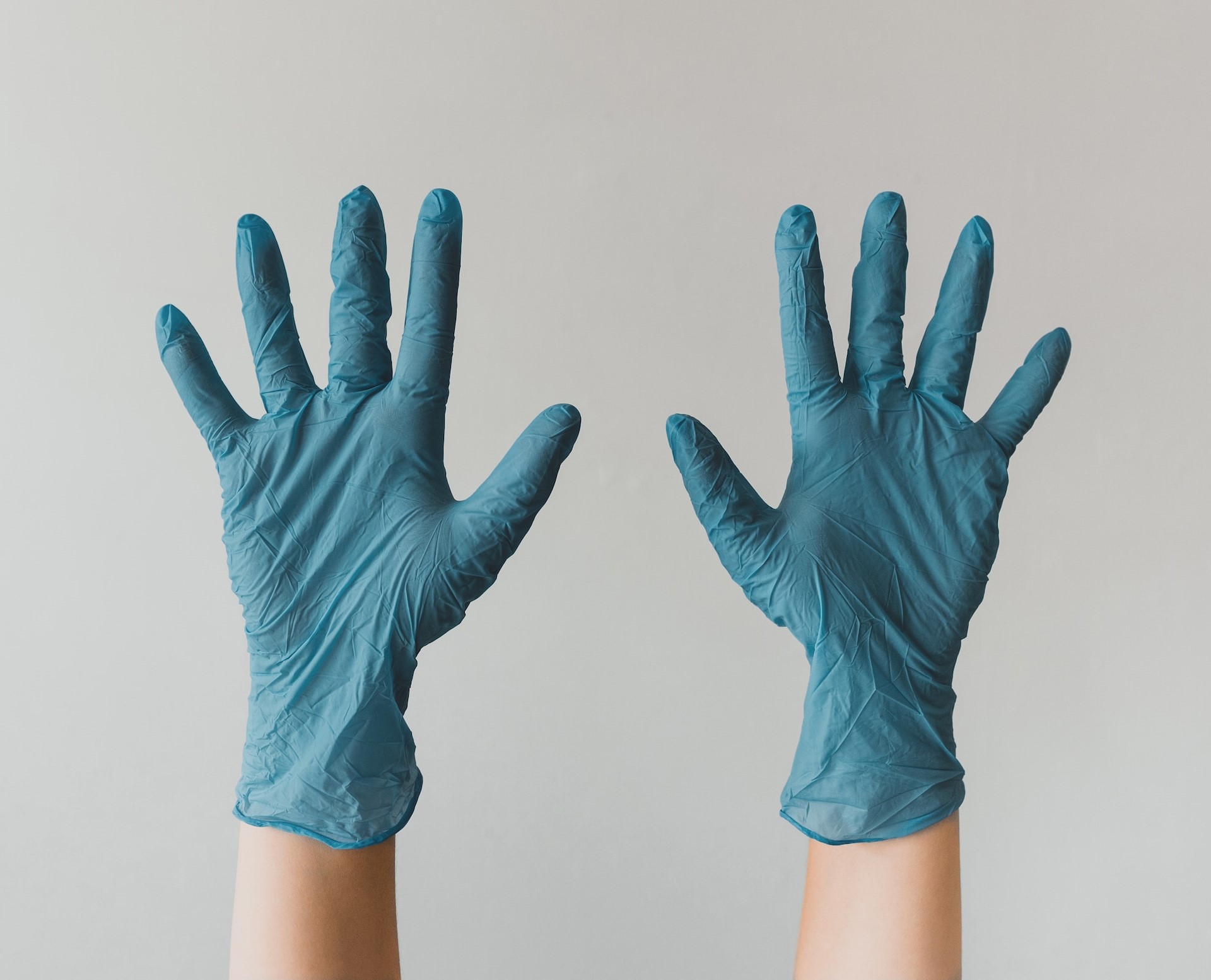 someone holding their hands up in rubber gloves