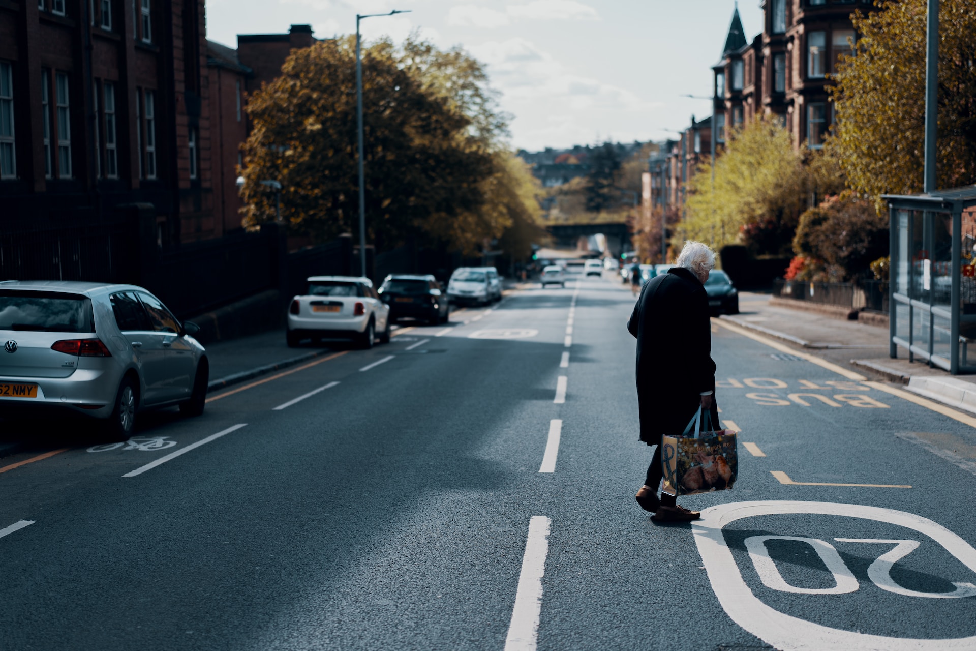 An elderly woman crossing a street