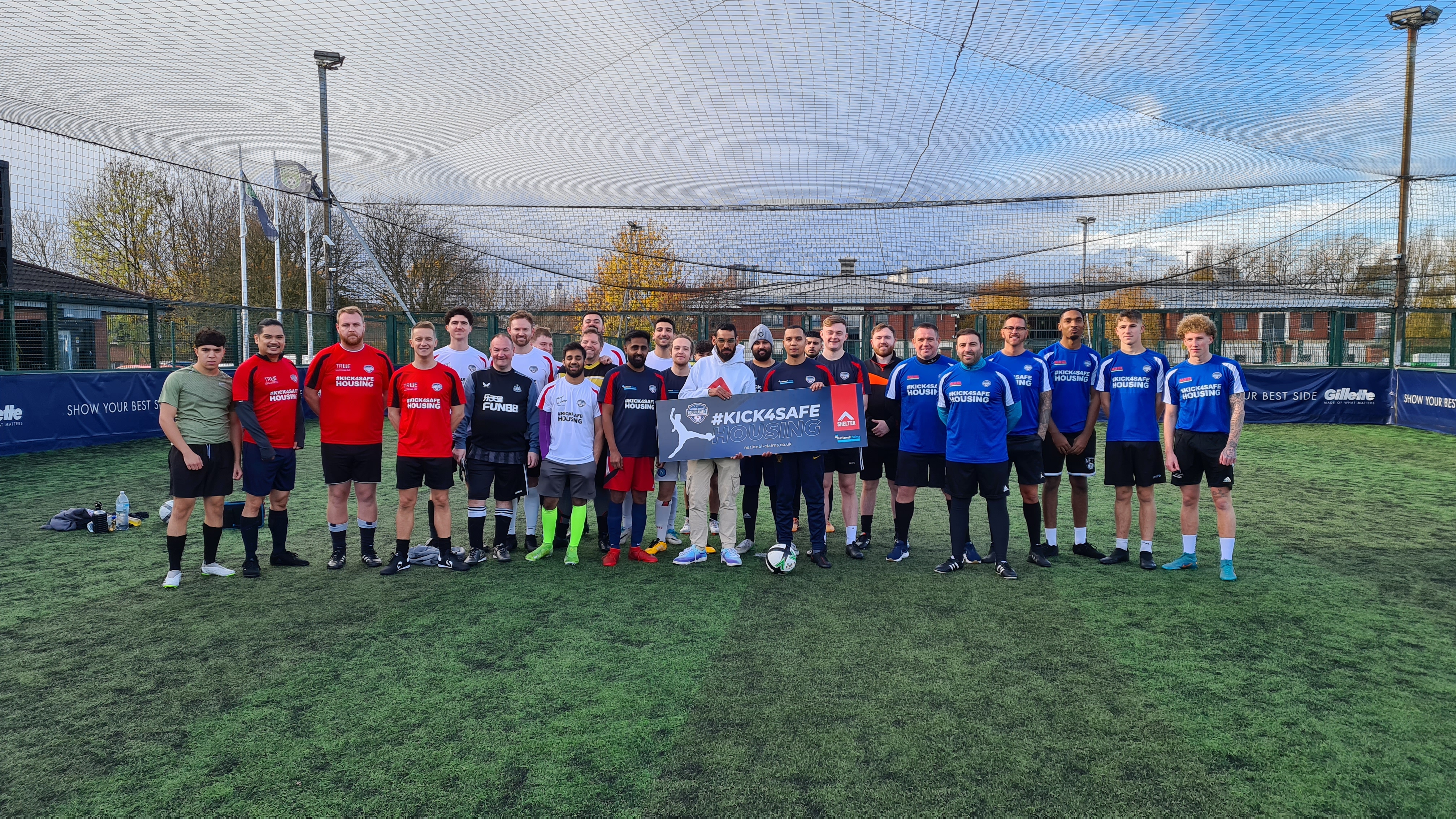 Group photo of every team at the tournament with the #kick4safehousing banner