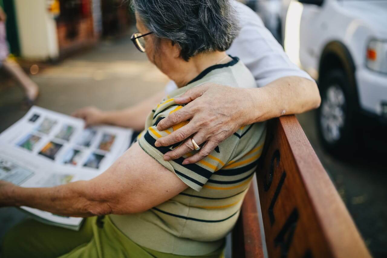 An older couple sat on a bench