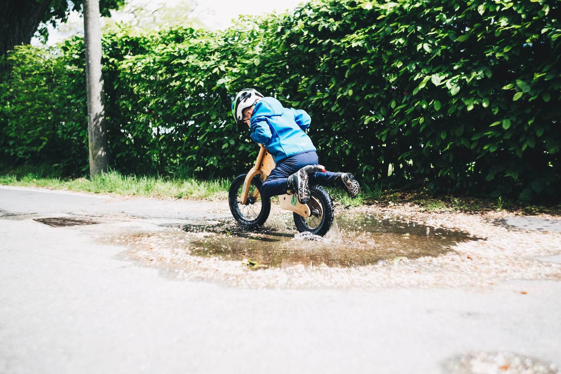 A child cycling through a puddle