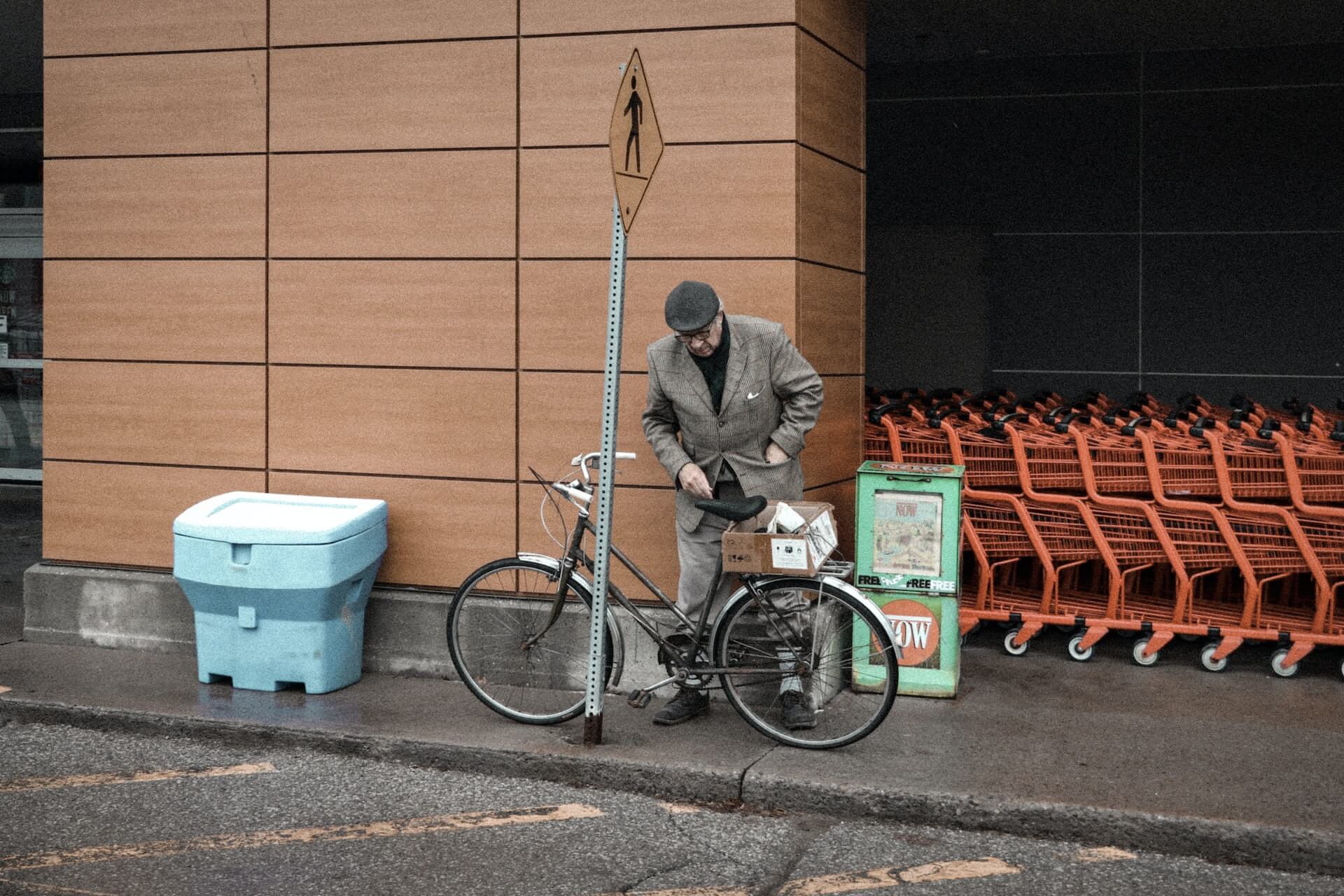 An older person parking their bicycle