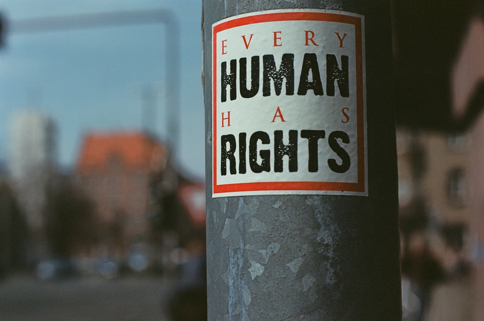 A sign saying 'every human has rights' on a lamppost