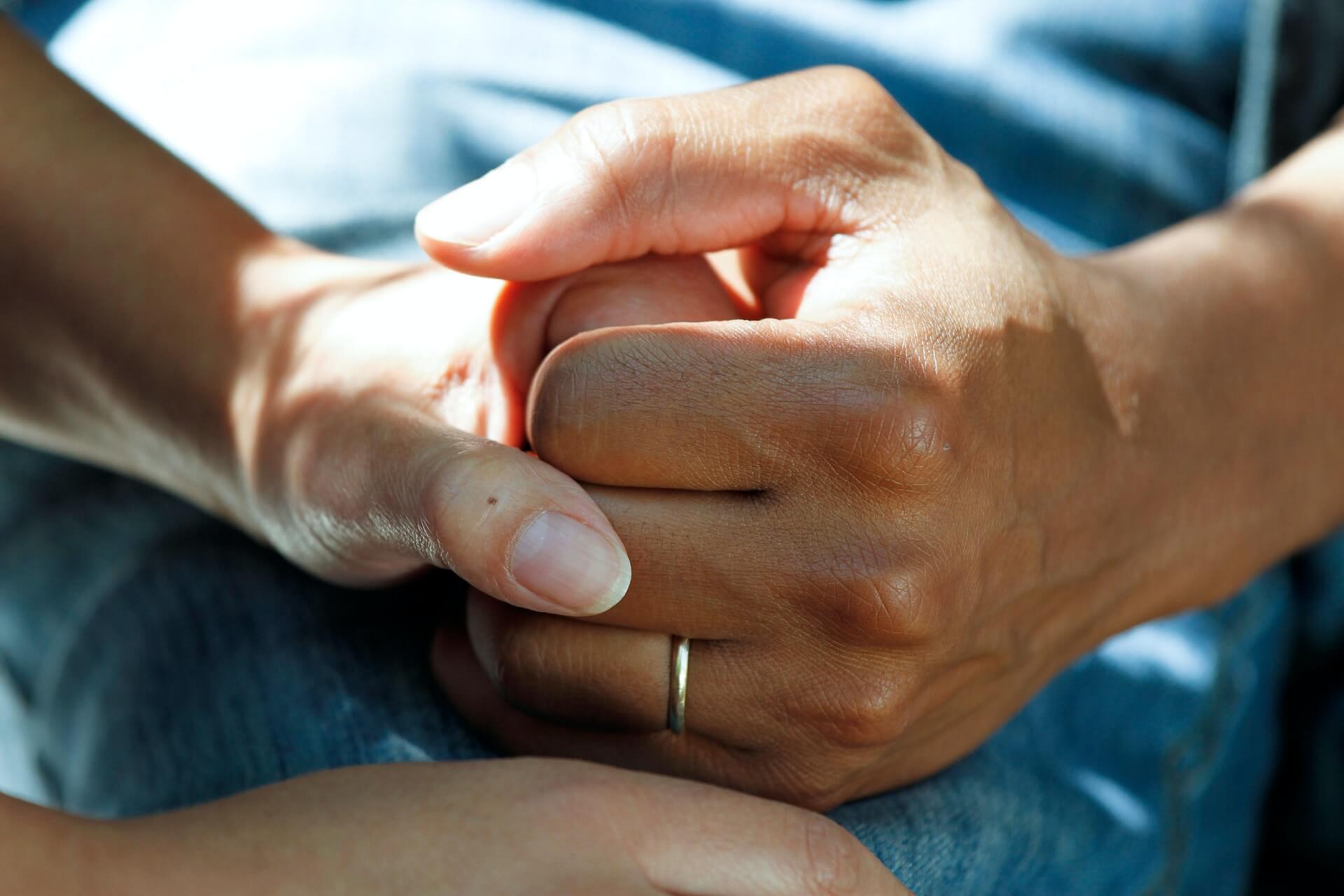 a carer and patient holding hands