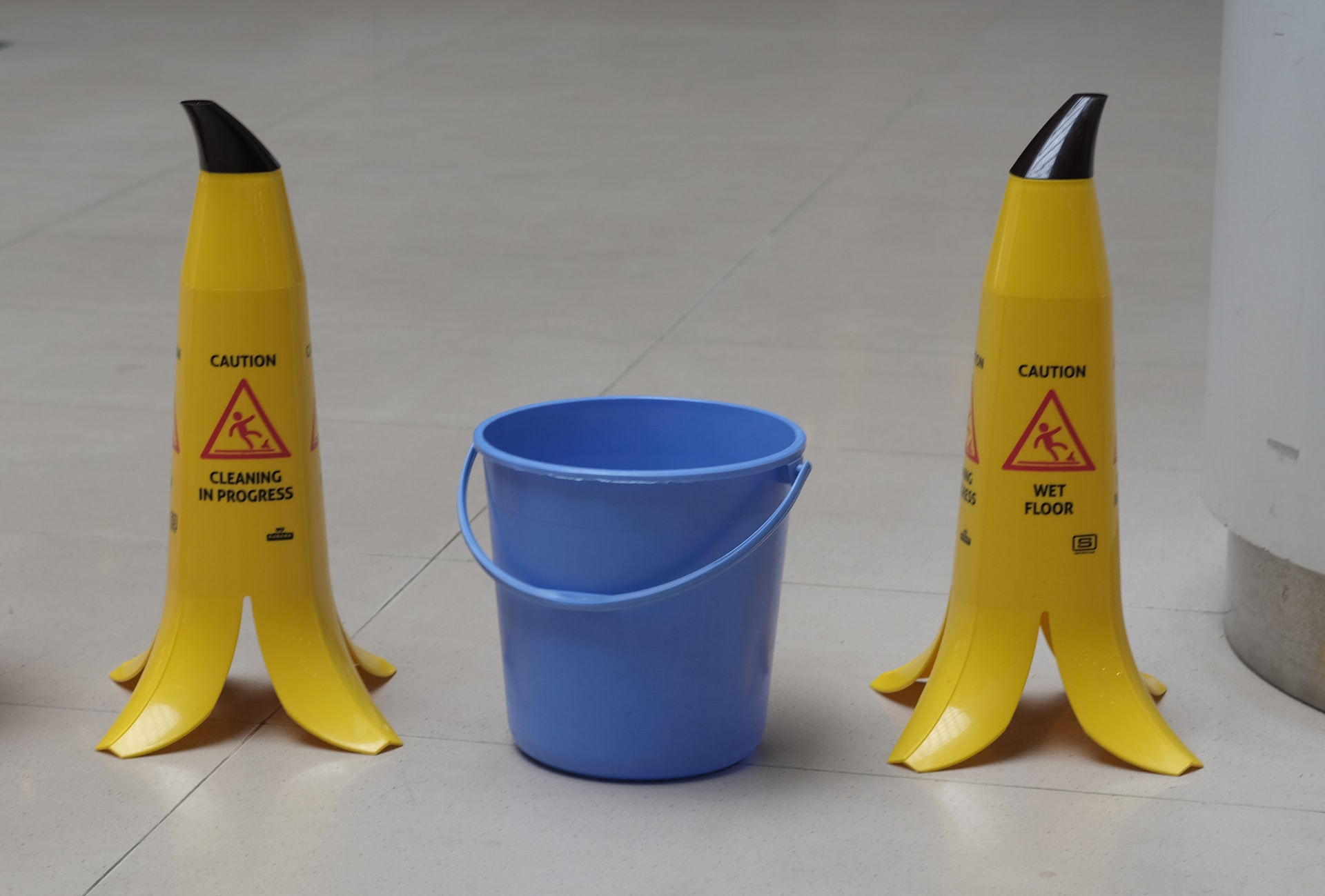 Two banana skin shaped 'cleaning in progress' signs with a bucket