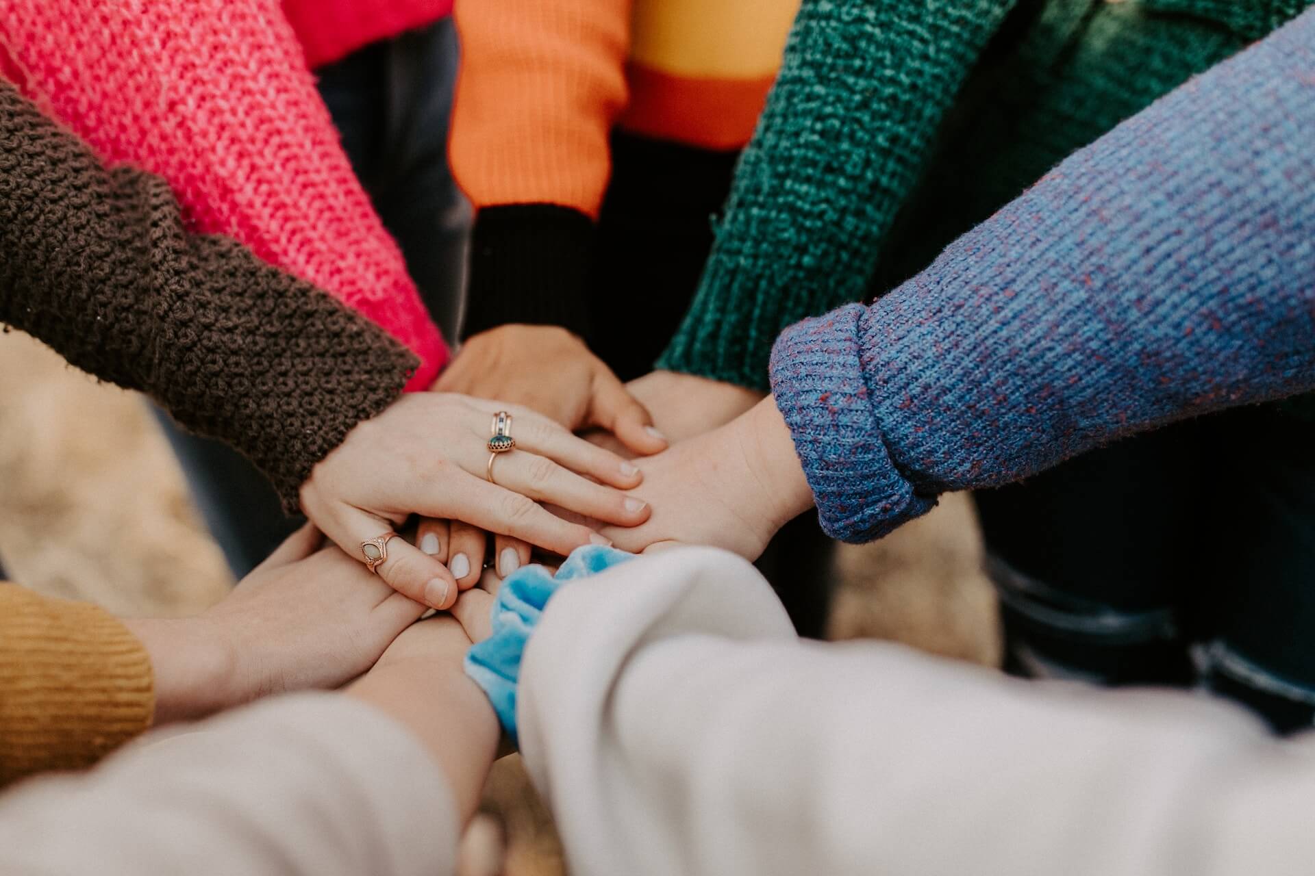 Group of people holding hands in the middle of a circle