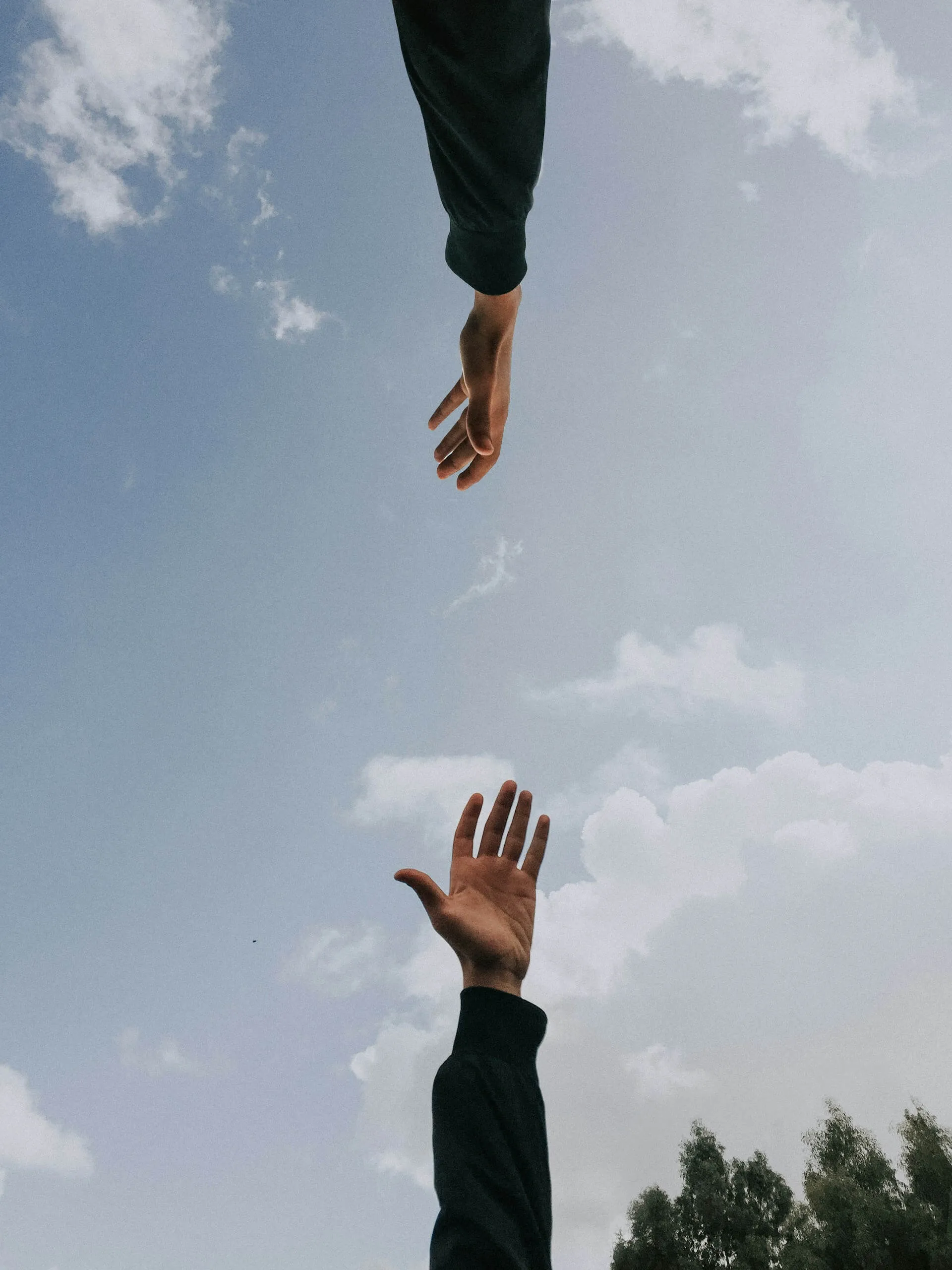 Two people reaching out their hands