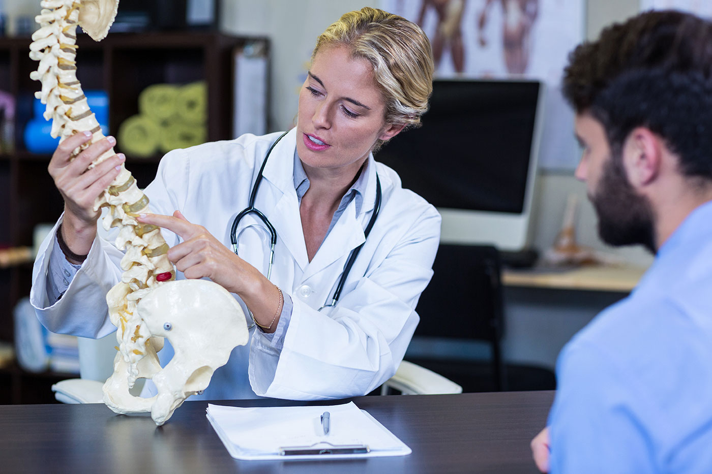 doctor explaining spine model to patient